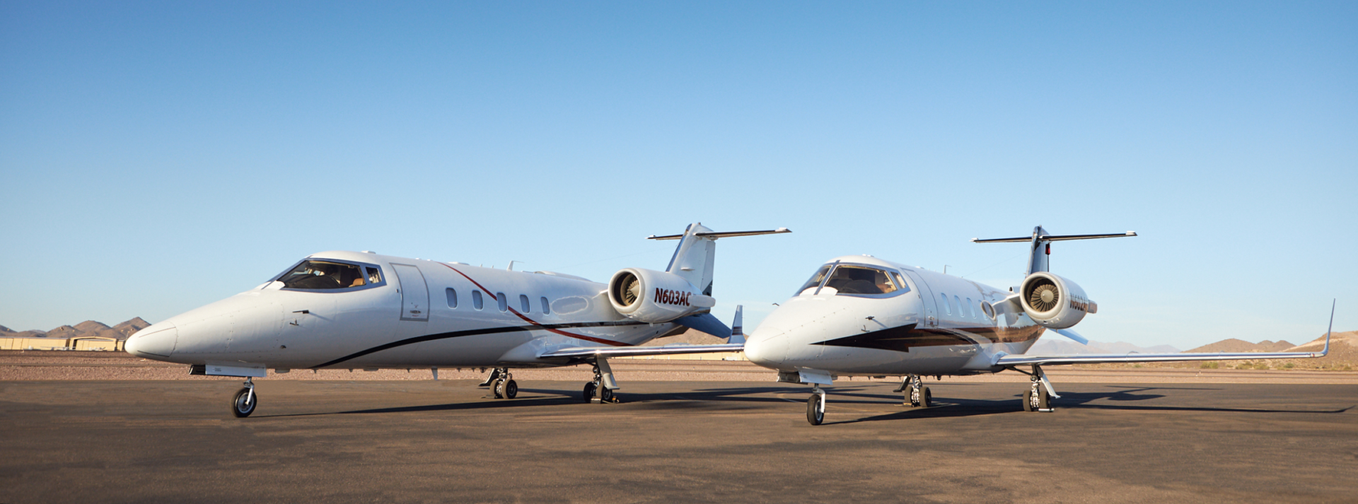 Full-sized double Learjet on runway side by side